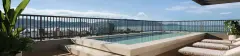 Piscina no rooftop com deck de madeira, espreguiçadeiras e vista panorâmica para o mar e a Baía Norte — A1 Elementos da Terra em Coqueiros, Florianópolis