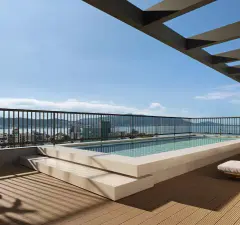 Piscina no rooftop com deck de madeira e pergolado, vista lateral para o mar — A1 Elementos da Terra em Coqueiros, Florianópolis