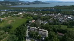 Vista aérea do empreendimento no bairro Cacupé com lagoa, montanhas e Florianópolis ao fundo — Adore Cacupé em Cacupé, Florianópolis