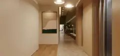 Hall de circulação com corredor em madeira, luminária pendente e planta decorativa — Adore Cacupé em Cacupé, Florianópolis