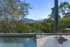 Piscina infinity com deck, cadeiras e vista para árvores e montanhas — Adore Canasvieiras em Canasvieiras, Florianópolis