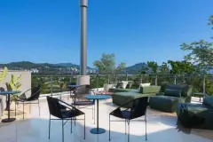 Espaço externo no terraço com sofás verdes e vista panorâmica para as montanhas e a cidade — Adore Canasvieiras em Canasvieiras, Florianópolis