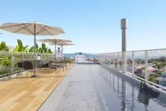 Piscina infinity no rooftop com deck de madeira e guarda-sol, vista panorâmica para o bairro — Adore Level Up em Cachoeira do Bom Jesus, Florianópolis