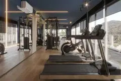 Academia com esteiras, bicicleta e aparelhos de peso, parede de vidro com vista para as montanhas — Adore Level Up em Cachoeira do Bom Jesus, Florianópolis