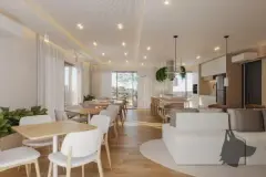 Salão gourmet com sofá, mesas, cozinha americana e janelas com vista para árvores — Adore Level Up em Cachoeira do Bom Jesus, Florianópolis