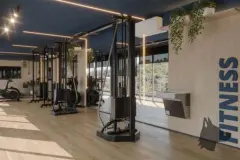 Academia fitness com aparelhos de musculação e parede de vidro com vista para árvores — Adore Level Up em Cachoeira do Bom Jesus, Florianópolis