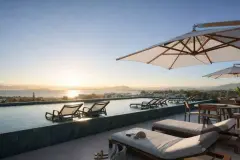 Perspectiva ilustrativa da piscina de borda infinita no rooftop ao pôr do sol com espreguiçadeiras e guarda-sol — Algae Beach Residence em Cachoeira do Bom Jesus, Florianópolis