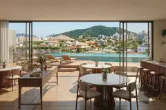 Perspectiva ilustrativa do salão gourmet com mesa redonda, bar, banquetas e janelão com vista para a piscina e o morro verde — Almare Jurerê em Jurerê, Florianópolis