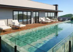 Piscina de borda infinita no rooftop com espreguiçadeiras brancas em deck de madeira e vista para o morro verde — Almare Jurerê em Jurerê, Florianópolis