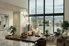 Sala de estar do duplex com pé direito duplo, janelão de vidro, mesa de jantar, escada de vidro e vista para os morros — Almare Jurerê em Jurerê, Florianópolis