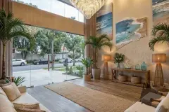 Horta e jardim no rooftop com alfaces, oliveira, vasos de concreto e sofá cinza com mesa de centro — Almare Jurerê em Jurerê, Florianópolis
