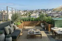 Brinquedoteca com tapete colorido, lego, carrinhos, puf amarelo e azul e varanda com mesa e vista para os morros — Almare Jurerê em Jurerê, Florianópolis