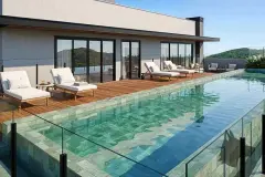 Vista aérea do bairro Jurerê com localização do empreendimento marcada por ícone azul e o mar ao fundo — Almare Jurerê em Jurerê, Florianópolis