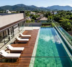 Piscina privativa da cobertura com mesa de jantar externa, churrasqueira e família reunida, sala duplex ao fundo — Almare Jurerê em Jurerê, Florianópolis