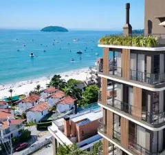 Perspectiva ilustrativa lateral do edifício Apoena Studios com varandas de madeira, rooftop verde e praia de Jurerê com barcos e ilha ao fundo — Apoena Studios em Jurerê, Florianópolis