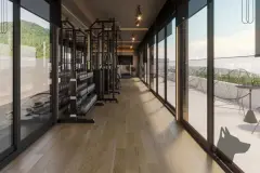 Perspectiva ilustrativa da academia com aparelhos de musculação, piso de madeira e parede de vidro com vista para o morro verde — Aquamarina Residence em Cachoeira do Bom Jesus, Florianópolis