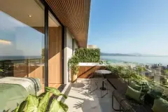Foto real da varanda de dormitório com jardim vertical, mesa e cadeiras, hidromassagem e vista panorâmica para a baía de Florianópolis — Art Blue View em Jurerê, Florianópolis