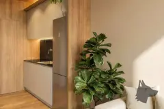 Foto real da cozinha compacta com bancada de granito preto, geladeira, armários de madeira e planta ornamental ficus — Art Blue View em Jurerê, Florianópolis