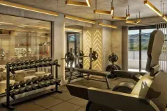 Perspectiva da academia com halteres, barra olímpica, cadeira articulada, iluminação dourada e janela com vista para os morros — Arts Home Design em Ingleses, Florianópolis