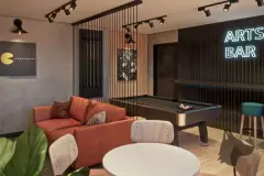 Perspectiva do Arts Bar com mesa de sinuca, sofá terracota, painel neon Arts Bar, iluminação spot e pôster Pac-Man decorativo — Arts Home Design em Ingleses, Florianópolis