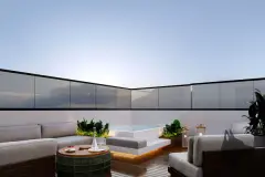 Perspectiva do terraço de cobertura noturno com sofá em L, mesa de centro, piscina plunge iluminada e plantas tropicais — At One Jurerê Studios em Jurerê, Florianópolis