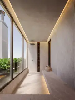 Perspectiva da área de banho externo com ducha embutida, paredes de microcimento, detalhe de pedra dourada e vegetação exuberante pela janela — Aura em Agronômica, Florianópolis