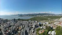 Vista aérea real marcando a localização do Aura Residence na Agronômica com Baía Norte, manguezal e morros ao fundo — Aura em Agronômica, Florianópolis