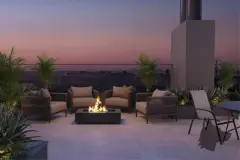 Perspectiva do terraço ao entardecer com fire pit retangular, poltronas de corda, palmeiras ornamentais e céu rosa e roxo ao fundo — Aura Residence em Capoeiras, Florianópolis