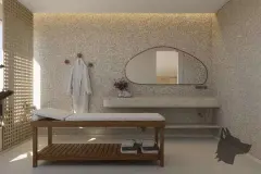 Perspectiva da sala de massagem com maca de madeira, espelho orgânico assimétrico, bancada de pedra com flores secas e biombo de ripas dourado — Aurea Marina em Cachoeira do Bom Jesus, Florianópolis