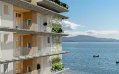 Perspectiva das varandas com fechamento de vidro e vista lateral para o mar turquesa e montanhas da ilha, ângulo alternativo — Aurea Marina em Cachoeira do Bom Jesus, Florianópolis