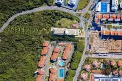 Foto aérea real do terreno do B7 Essence Brava com vegetação nativa ao lado e bairro ao redor - ângulo alternativo — B7 Essence Brava em Praia Brava, Florianópolis