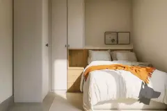 Perspectiva do quarto do apartamento do B7 Essence Brava com cama de casal, closet embutido e manta laranja — B7 Essence Brava em Praia Brava, Florianópolis