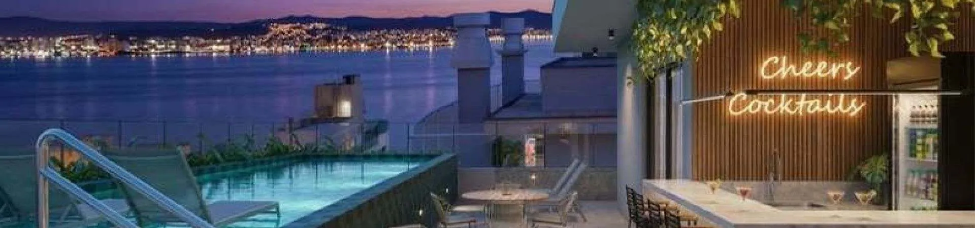 Perspectiva do rooftop do B7 Park Marina à noite com piscina, área de estar e cocktail bar com vista para a Baía Norte — B7 Park Marina em Agronômica, Florianópolis