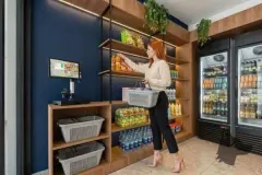 Foto da loja de conveniência do B7 Park Marina, ângulo alternativo, com cliente e produtos nas prateleiras — B7 Park Marina em Agronômica, Florianópolis
