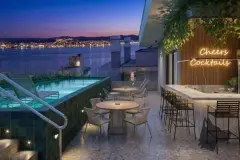 Perspectiva do rooftop do B7 Park Marina com piscina, drink bar iluminado e vista para a Baía Norte à noite — B7 Park Marina em Agronômica, Florianópolis