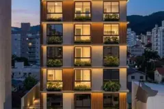 Perspectiva da fachada do B7 Park Marina ao entardecer, iluminada por dentro, vista lateral — B7 Park Marina em Agronômica, Florianópolis