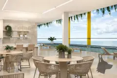 Perspectiva do salão com mesas, cadeiras de fibra natural e vista para o mar e piscina com pilares amarelos — Barra 4 Club Residence em Barra da Lagoa, Florianópolis