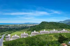 Vista aérea lateral do Bellomonte Residence em encosta verde com Baía Norte e ilhas ao fundo — Bellomonte Residence em Ingleses, Florianópolis