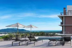 Área da piscina no rooftop com espreguiçadeiras, guarda-sóis e vista panorâmica para o Morro dos Ingleses e mar — Bellomonte Residence em Ingleses, Florianópolis