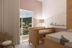 Quarto infantil com berço de madeira, parede rosa com logotipo Helena, poltrona em rattan e varanda com vista para morro — Beriyth Residence em Cachoeira do Bom Jesus, Florianópolis