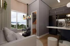 Sala de estar integrada à cozinha escura, sofá cinza, bancada em mármore e janela com vista para a baía — Beriyth Residence em Cachoeira do Bom Jesus, Florianópolis