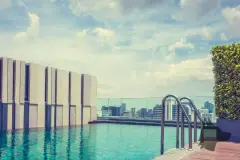 Piscina com borda infinita no rooftop com corrimão metálico, jardim e vista panorâmica para a cidade — BG Connect Canas em Canasvieiras, Florianópolis