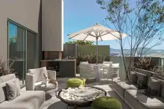 Terraço privativo com sofás cinza, churrasqueira, mesa de jantar e vista panorâmica para as montanhas — BG Connect Canas em Canasvieiras, Florianópolis