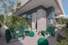 Terraço privativo com poltronas verdes e mesa lateral, churrasqueira ao fundo e jardim vertical — BG Connect Trindade 2 em Trindade, Florianópolis