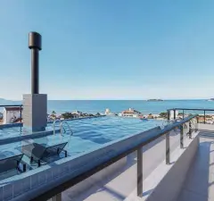 Piscina de borda infinita no rooftop do Bohn Residence com espreguiçadeiras e vista para o mar dos Ingleses — Bohn Residence em Ingleses, Florianópolis