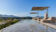 Piscina de borda infinita no rooftop com espreguiçadeiras e guarda-sol com vista para as montanhas e a lagoa — Brisa do Leste Residence em Barra da Lagoa, Florianópolis