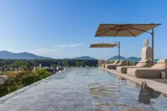Piscina de borda infinita no rooftop com espreguiçadeiras e guarda-sóis com vista para as montanhas — ângulo alternativo — Brisa do Leste Residence em Barra da Lagoa, Florianópolis