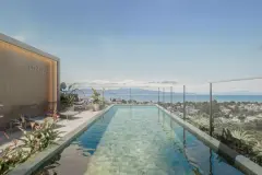 Piscina de borda com pastilhas verdes no rooftop do Brizz Smart Stay, espreguiçadeiras e vista para o mar — Brizz Smart Stay em Cachoeira do Bom Jesus, Florianópolis
