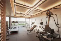 Academia com teto em madeira iluminado, esteiras, gaiola de treino, halteres e janelão com vista para as montanhas — Brizz Smart Stay em Cachoeira do Bom Jesus, Florianópolis