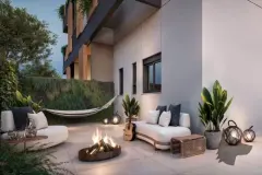 Varanda tipo garden ao entardecer com sofá, fire pit, rede, violão, lanternas e jardim — Brizz Smart Stay em Cachoeira do Bom Jesus, Florianópolis